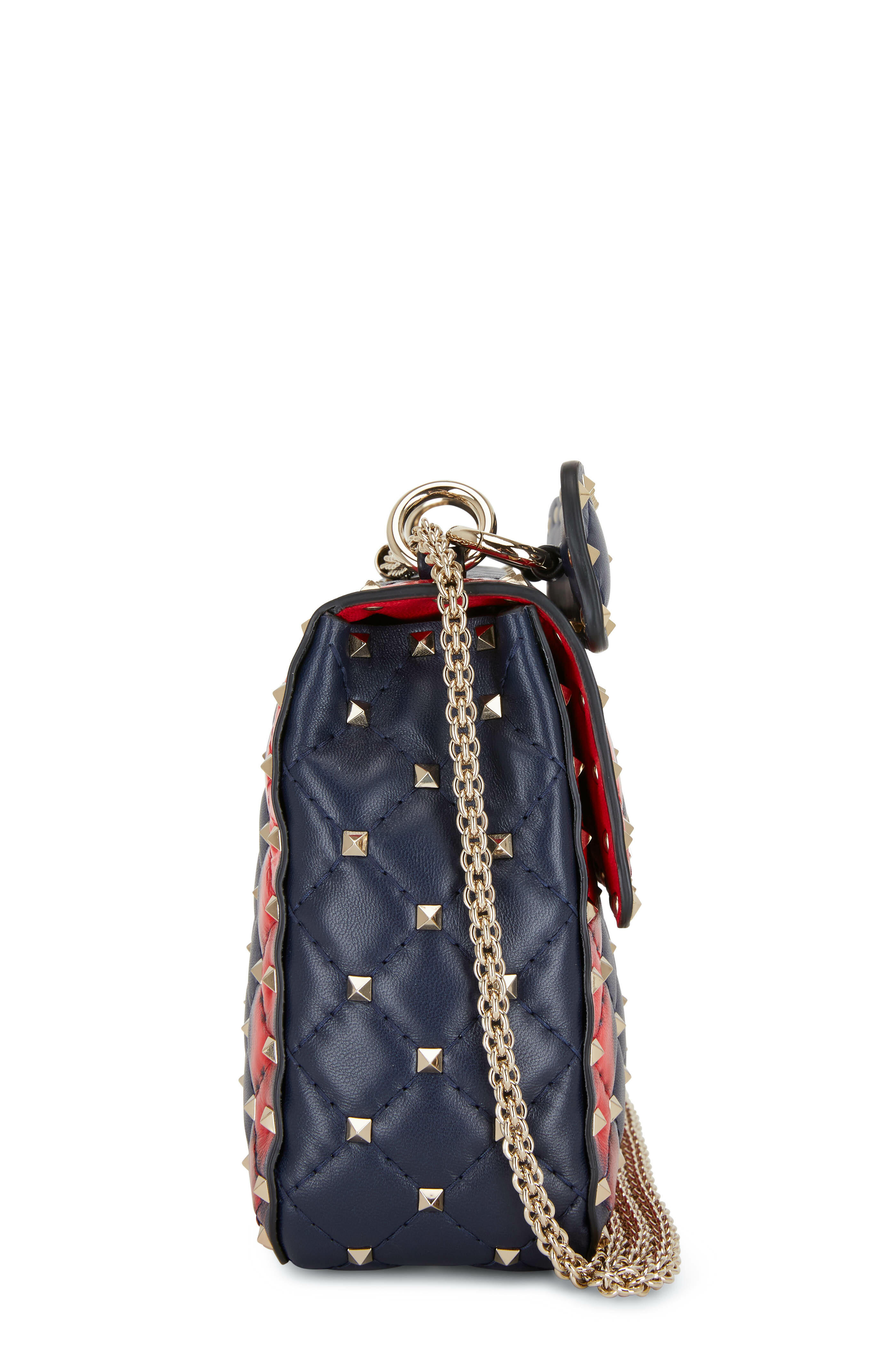A brown and red heart bag by Louis Vuitton, white studded sneakers